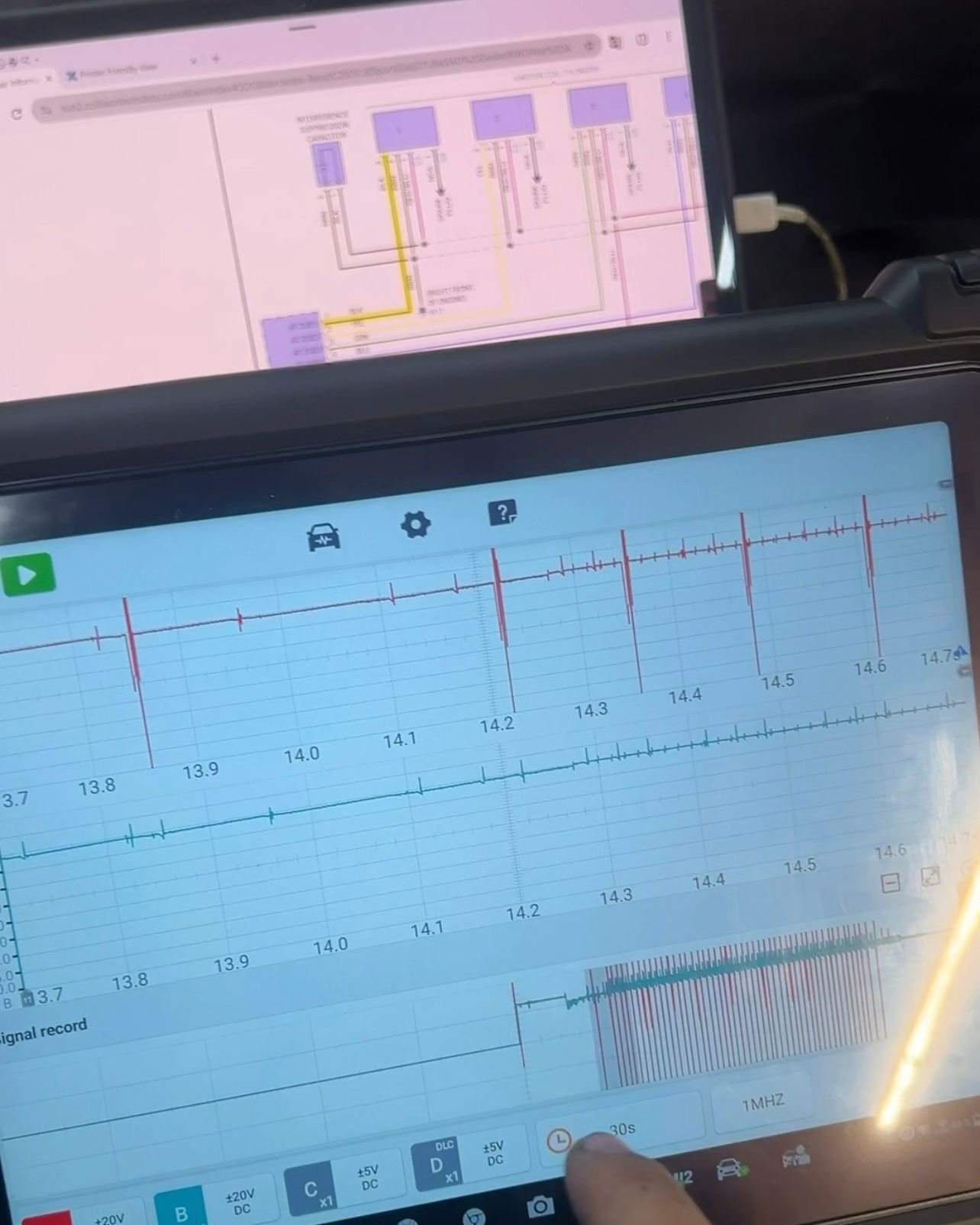 Diagnostic scope screen showing two voltage waveforms being recorded, with a vehicle wiring diagram open on a second tablet