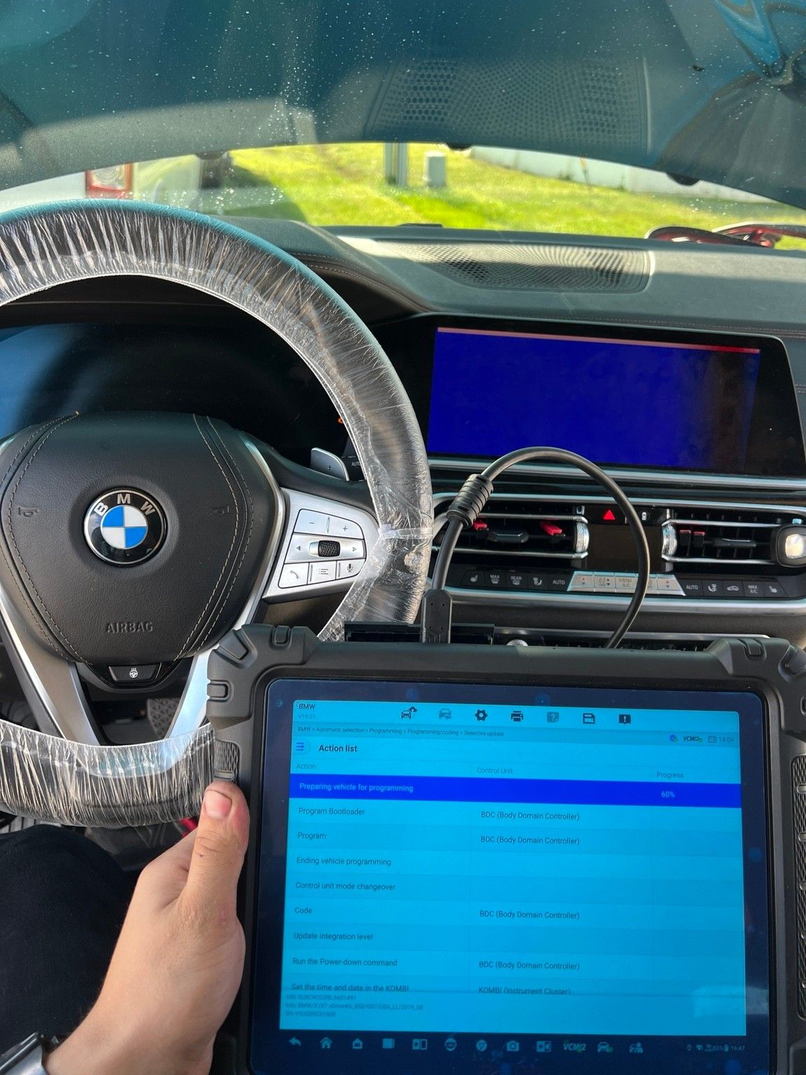 Programming tablet connected inside a BMW, running a selective update that programs and codes the BDC (Body Domain Controller)