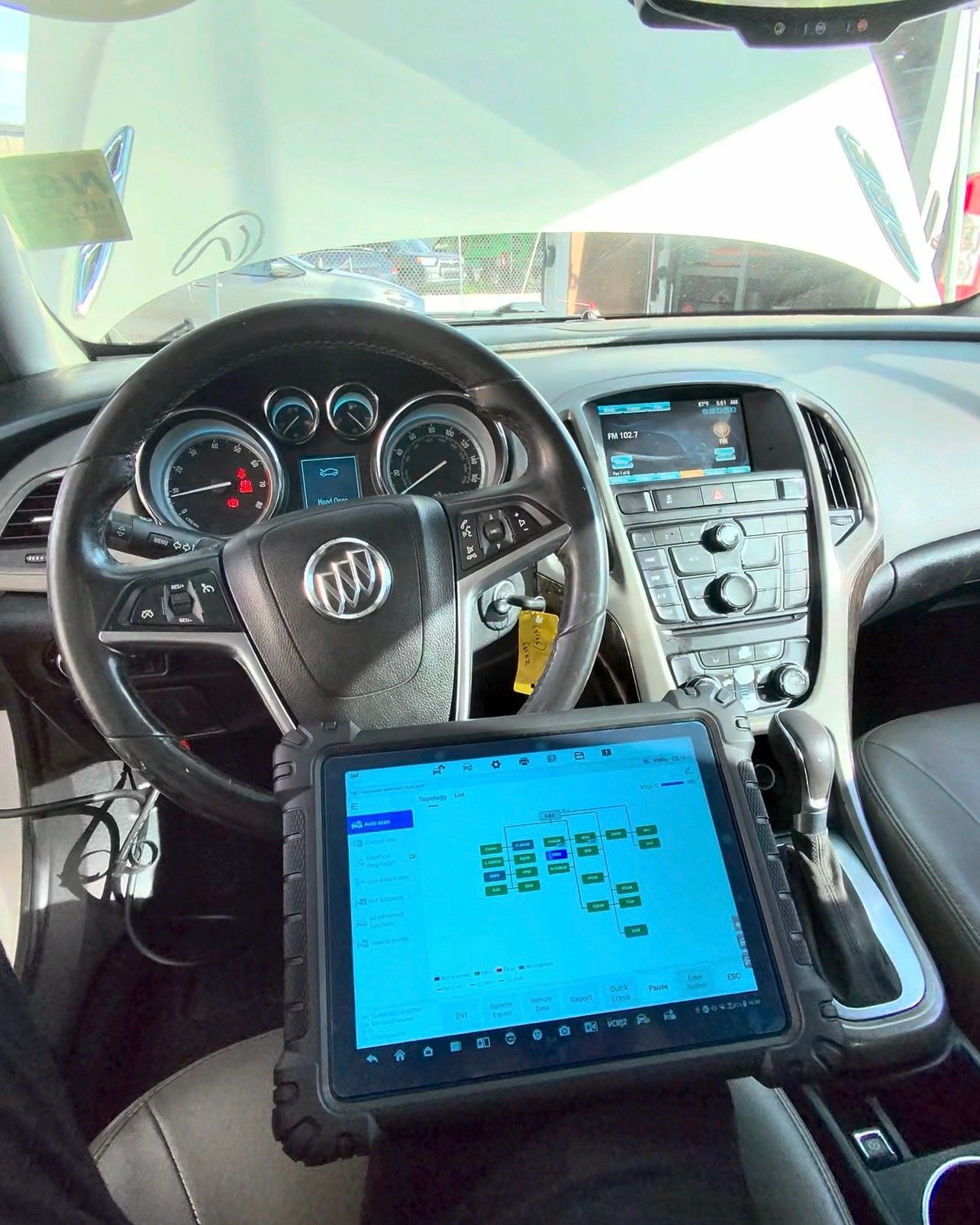 Diagnostic scan tablet showing a vehicle module network scan, set up inside a Buick